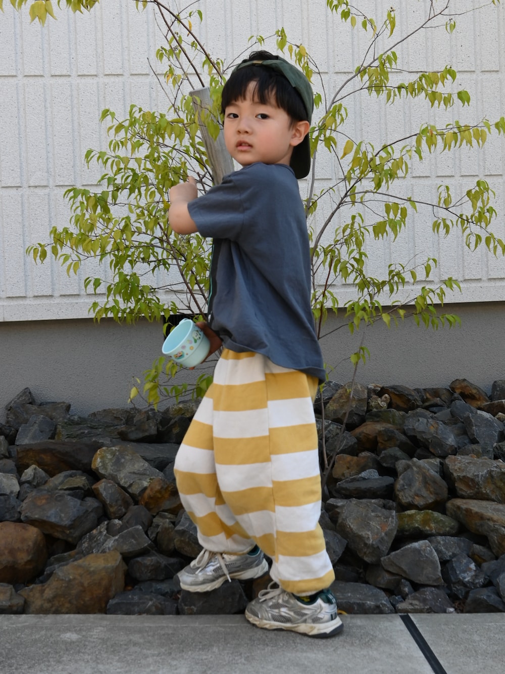 グレー系のTシャツ/カットソー、イエロー系のスウェットパンツ、シルバー系のスニーカーを着用したキッズの春コーディネートの2枚目の写真