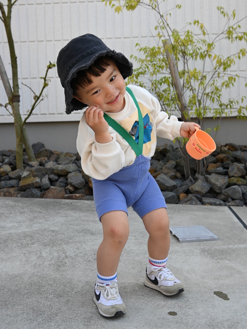 ブルー系のパンツ、ホワイト系のスニーカー、ブラック系のハットを着用したキッズの春コーディネートの2枚目の写真