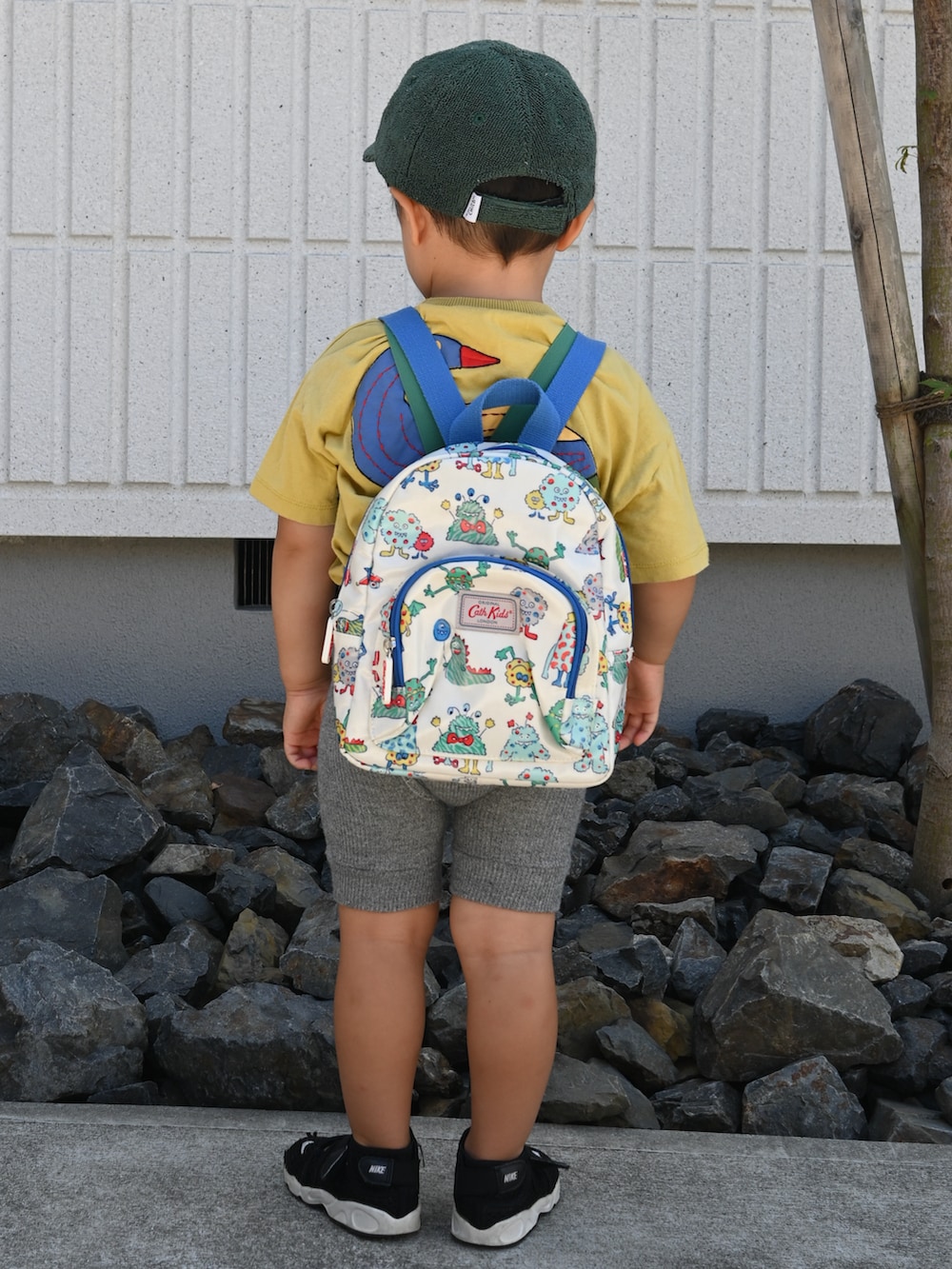 イエロー系のトップス、グレー系のパンツ、ブラック系のスニーカーを着用したキッズの夏コーディネートの2枚目の写真