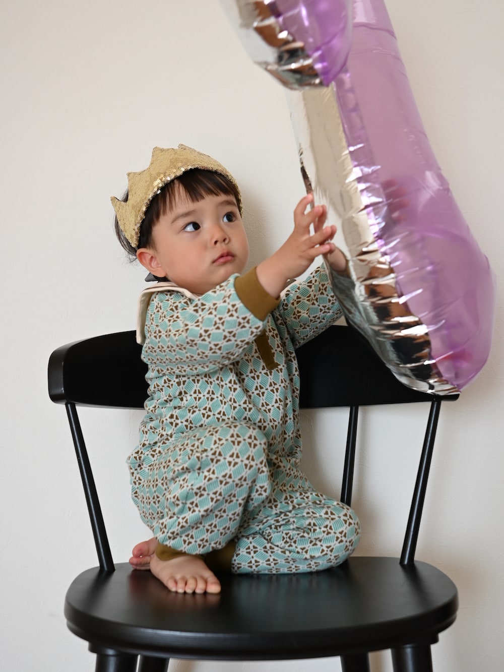 グリーン系のセットアップ、ゴールド系のヘアアクセサリーを着用したキッズの春コーディネートの2枚目の写真