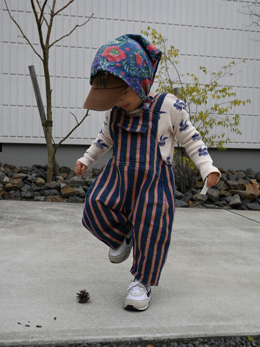 ベージュ系のTシャツ/カットソー、ブルー系のオールインワン・サロペット、ホワイト系のスニーカーを着用したキッズの冬コーディネートの3枚目の写真