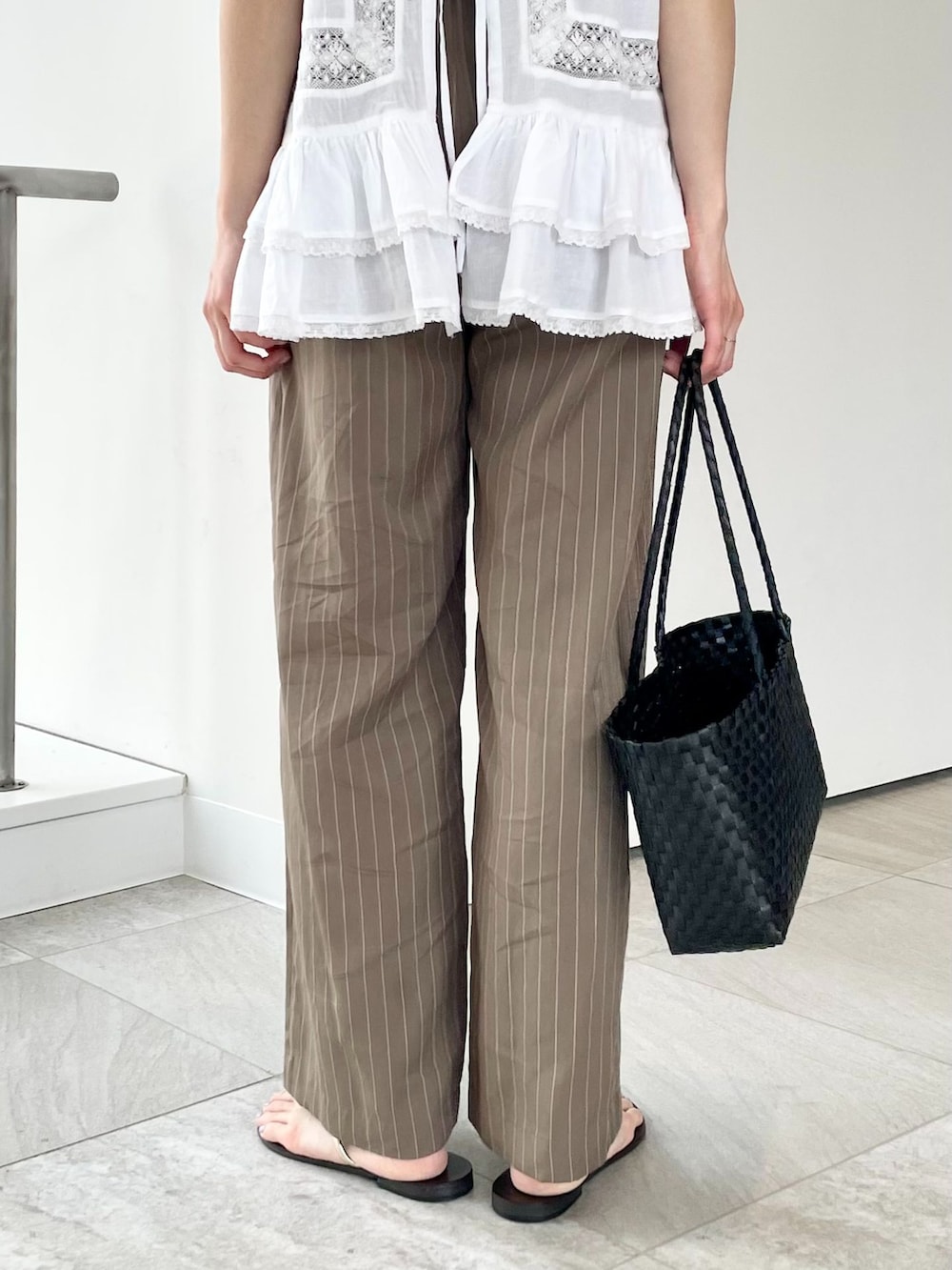 グリーン系のその他パンツ、ホワイト系のシャツ/ブラウス、パープル系のタンクトップを着用したレディースの春コーディネートの4枚目の写真