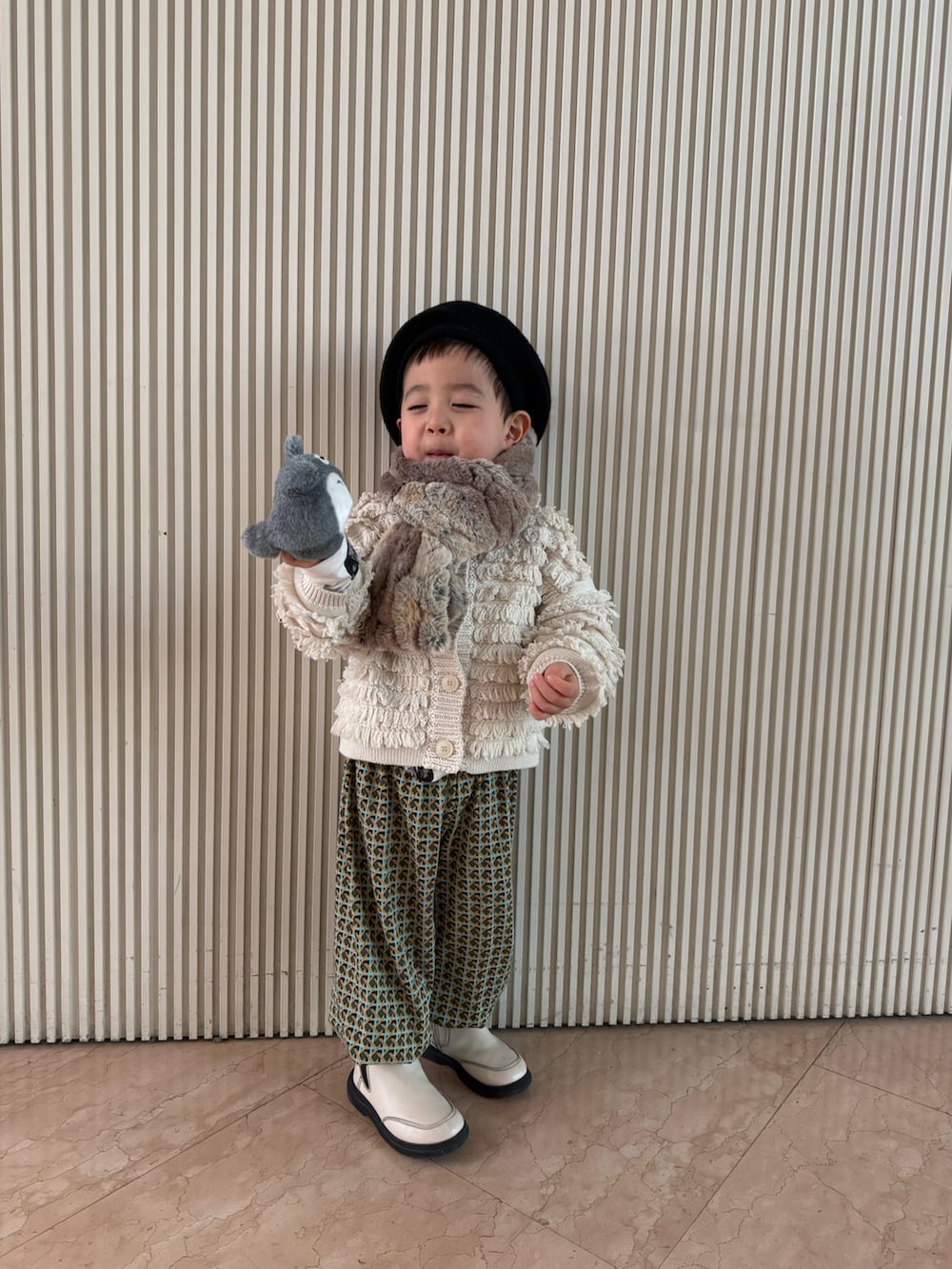 ホワイト系のカーディガン/ボレロ、その他のパンツ、ベージュ系のマフラーを着用したキッズの春コーディネートの2枚目の写真