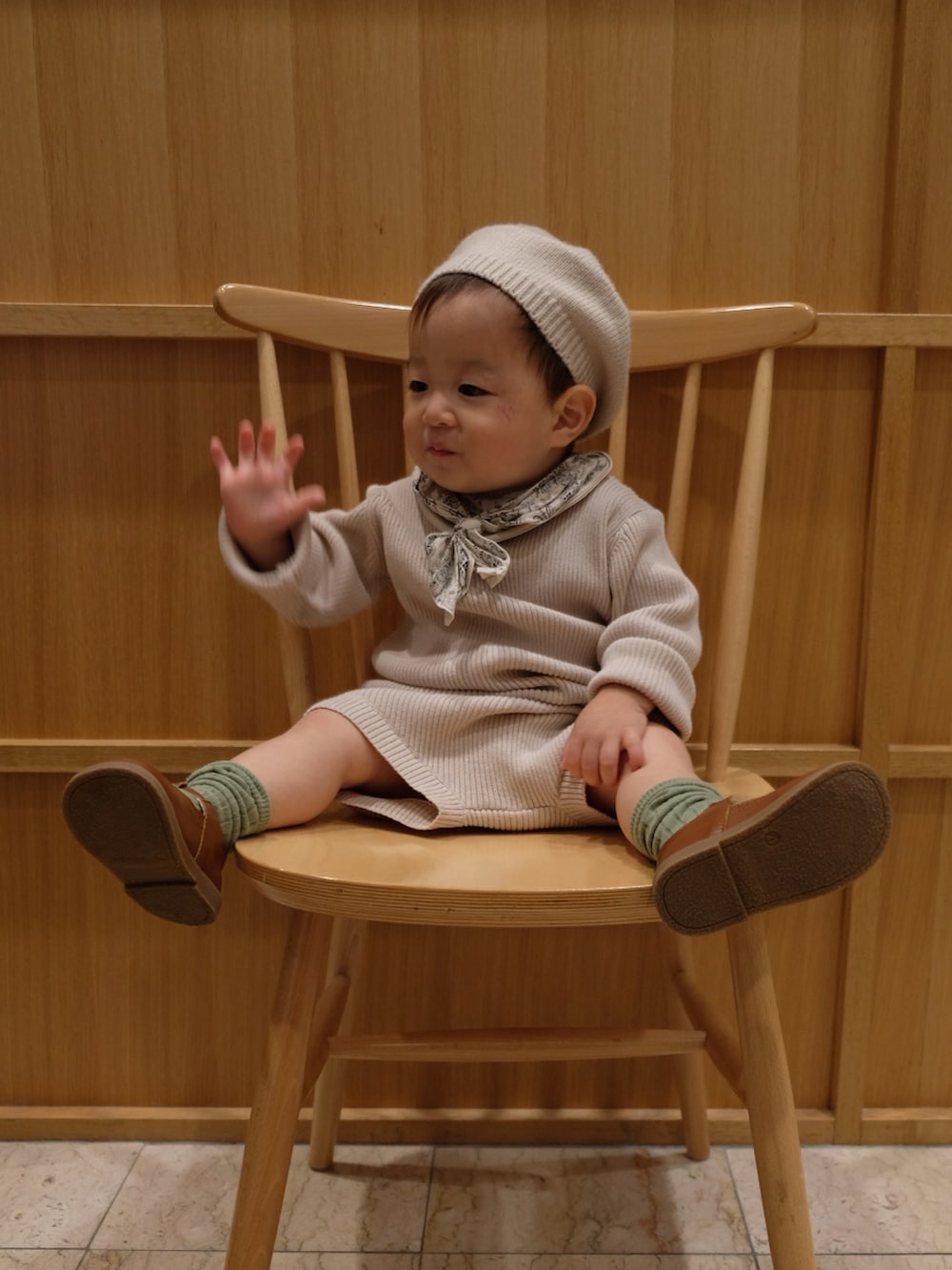 ベージュ系のニット/セーター、ホワイト系のスタイ/よだれかけを着用したキッズの春コーディネートの2枚目の写真