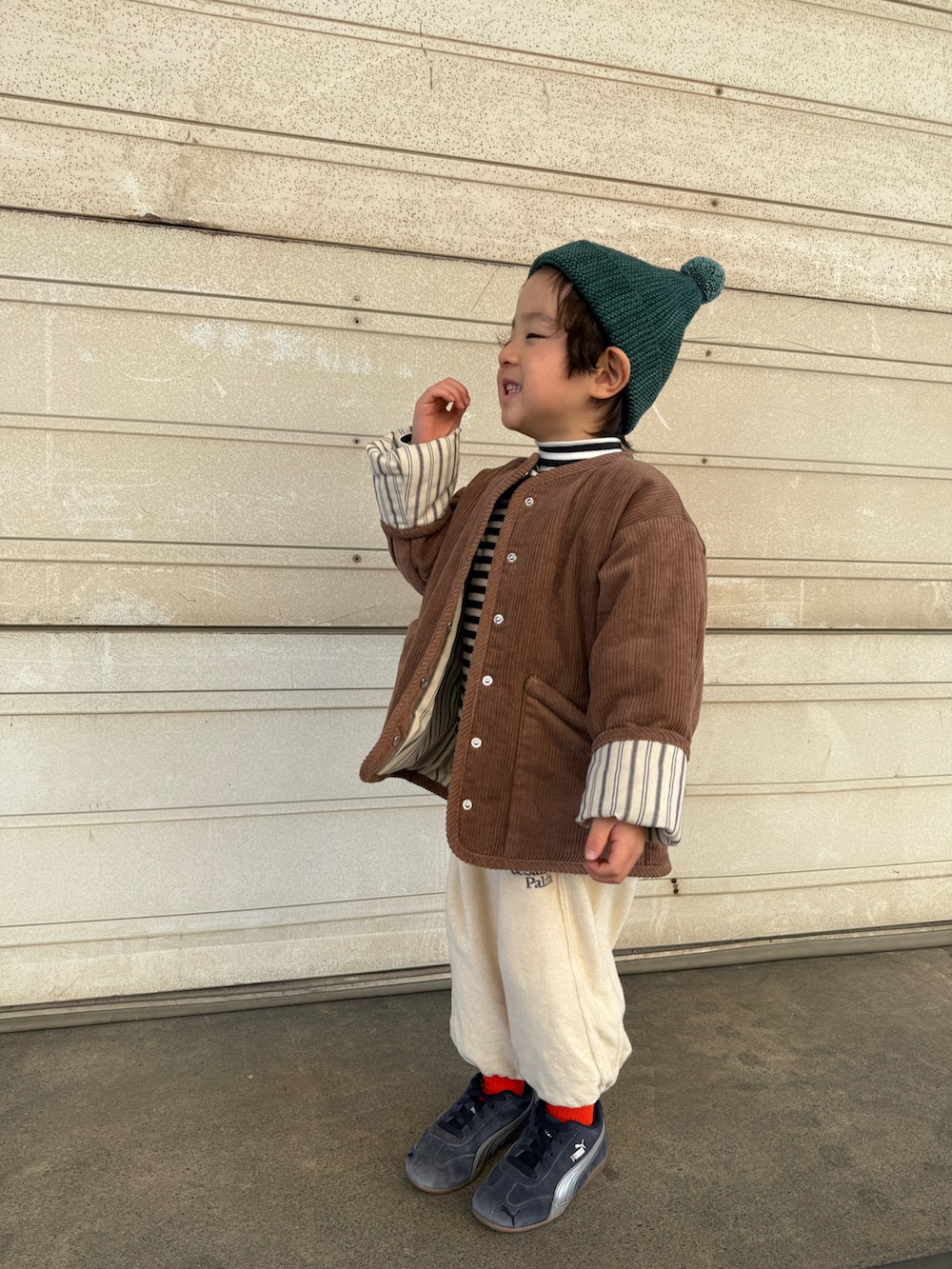 ブルー系のスニーカー、ブラウン系のジャケット/アウター、ホワイト系のパンツを着用したキッズの春コーディネートの3枚目の写真