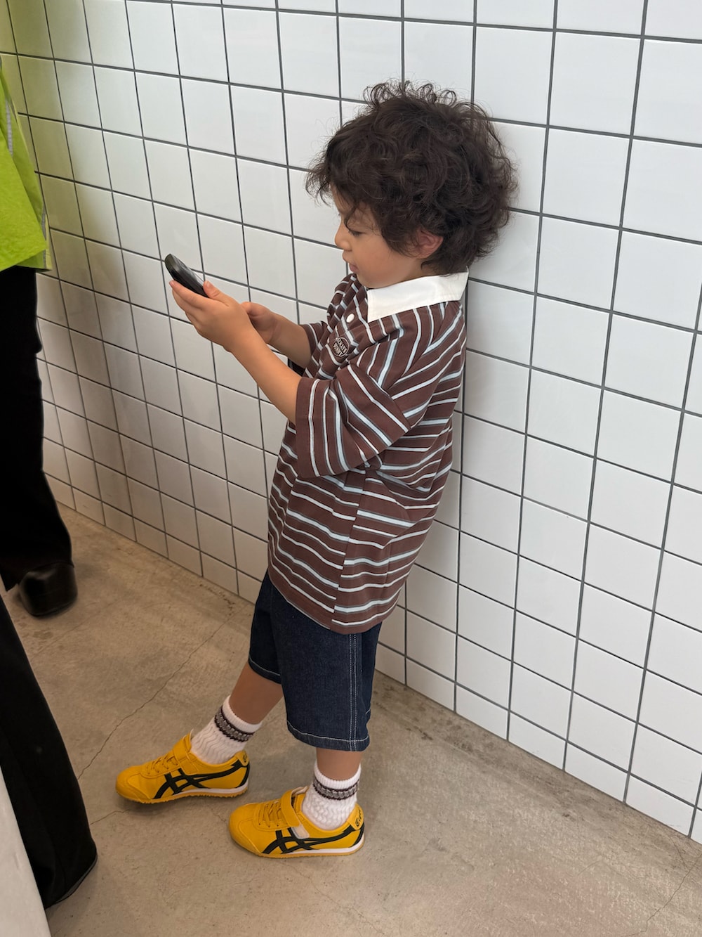 ブラウン系のその他トップス、ブルー系のデニムパンツ、イエロー系のスニーカーを着用したキッズの秋コーディネートの2枚目の写真