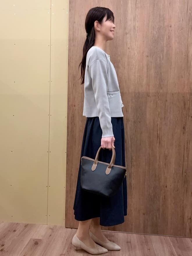 グレー系のワンピース、グレー系のカーディガン/ボレロ、ブラック系のトートバッグを着用したレディースの春コーディネートの2枚目の写真