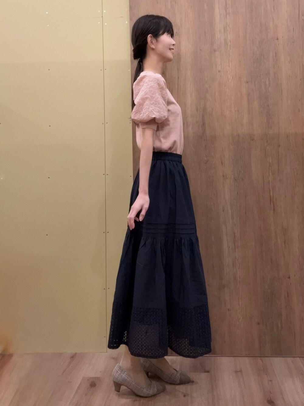 ブラウン系のパンプス、ピンク系のニット/セーター、ブルー系のスカートを着用したレディースの春コーディネートの2枚目の写真