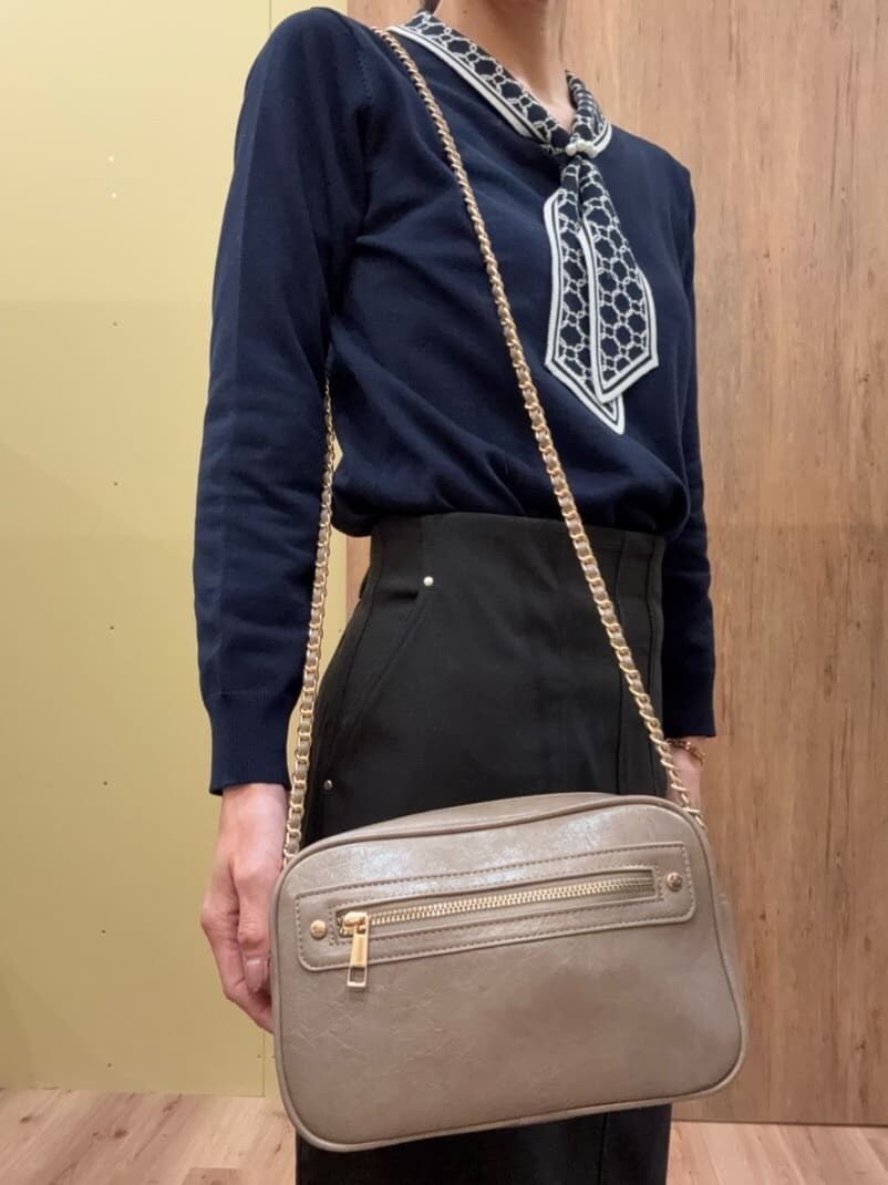 グレー系のショルダーバッグ、ベージュ系のパンプス、ブルー系のニット/セーターを着用したレディースの春コーディネートの6枚目の写真