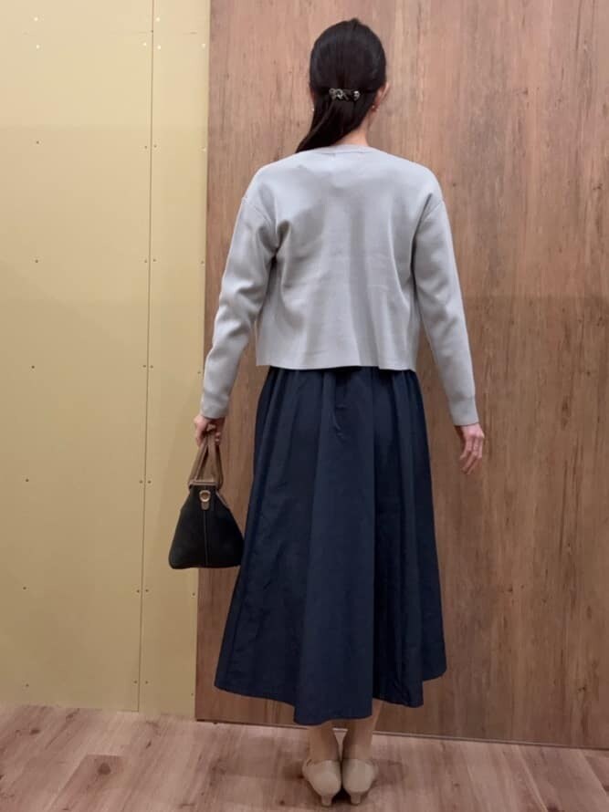 グレー系のワンピース、グレー系のカーディガン/ボレロ、ブラック系のトートバッグを着用したレディースの春コーディネートの3枚目の写真