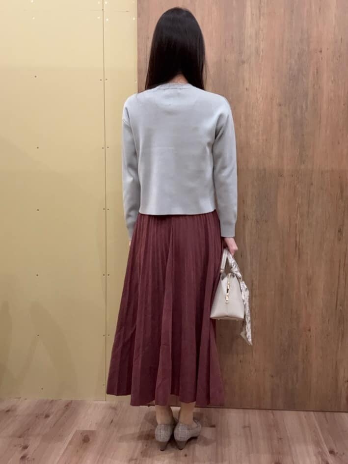 グレー系のカーディガン/ボレロ、レッド系のスカート、グレー系のハンドバッグを着用したレディースの冬コーディネートの3枚目の写真