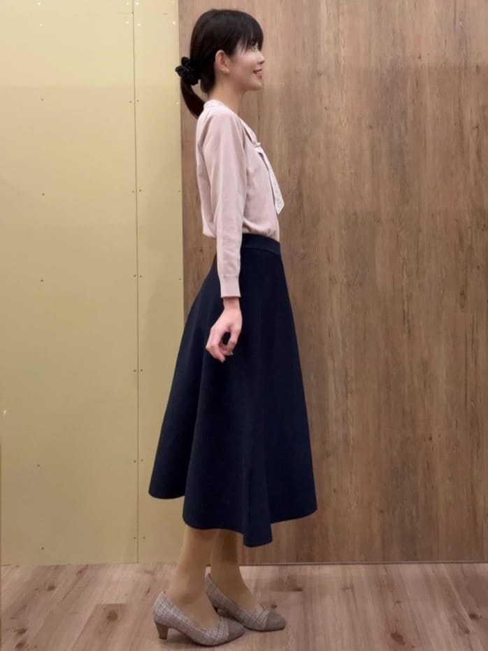 ブラウン系のパンプス、ブルー系のスカート、ピンク系のニット/セーターを着用したレディースの春コーディネートの2枚目の写真