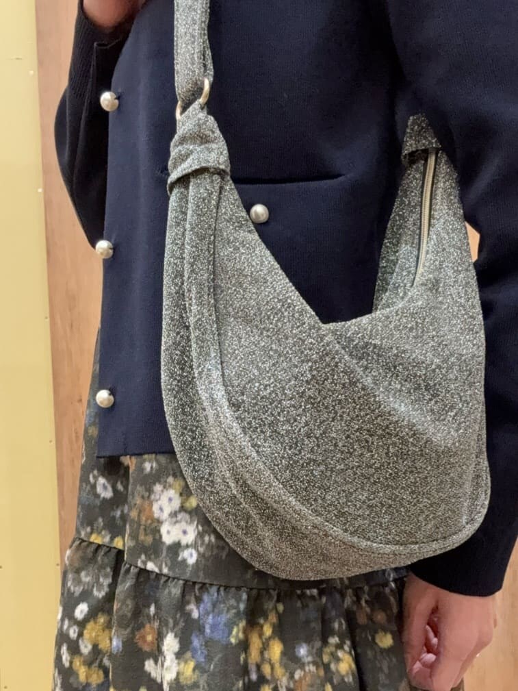 ブラック系のパンプス、シルバー系のショルダーバッグ、グリーン系のワンピースを着用したレディースの冬コーディネートの5枚目の写真