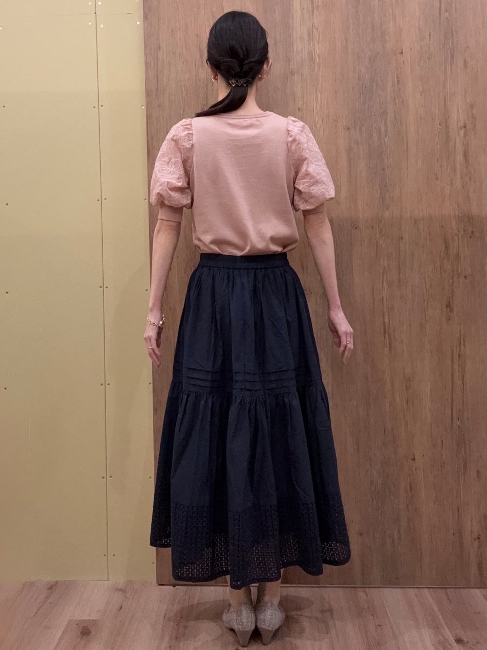 ブラウン系のパンプス、ピンク系のニット/セーター、ブルー系のスカートを着用したレディースの春コーディネートの3枚目の写真