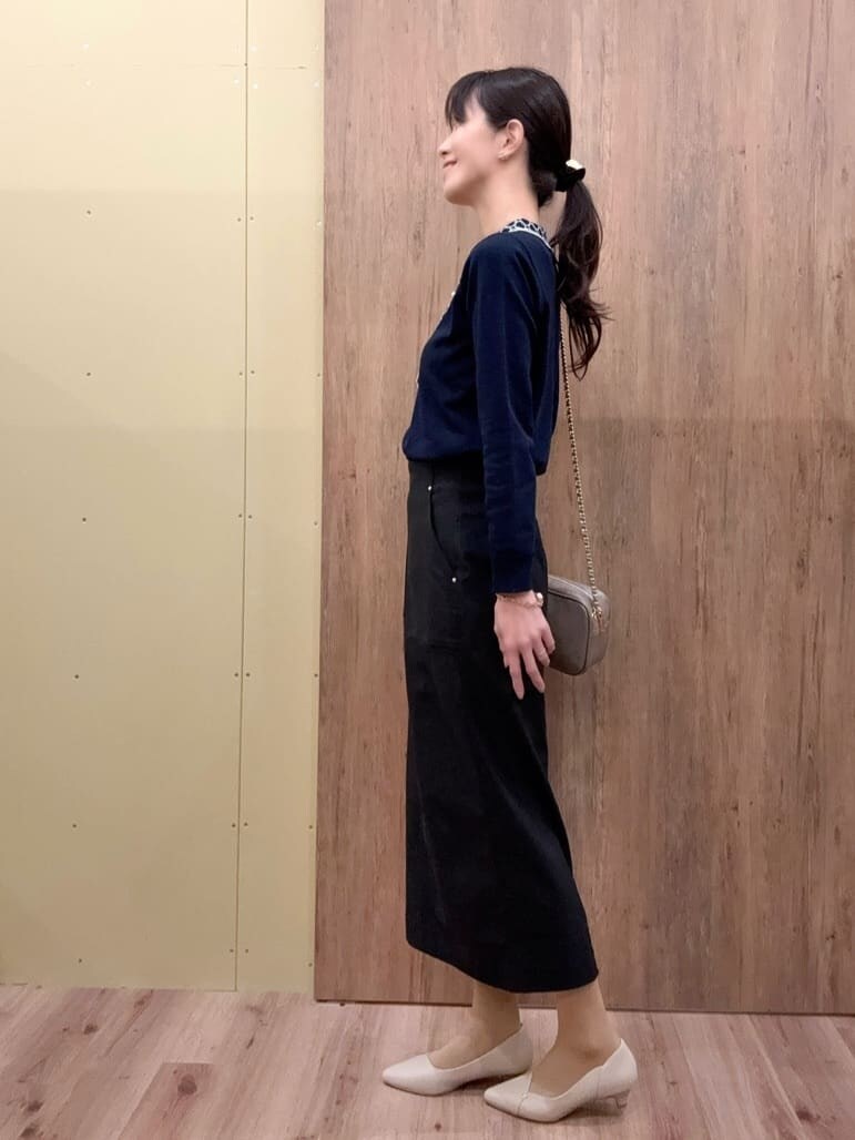 グレー系のショルダーバッグ、ベージュ系のパンプス、ブルー系のニット/セーターを着用したレディースの春コーディネートの3枚目の写真