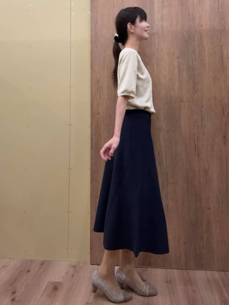 ブラウン系のパンプス、ブルー系のスカート、ゴールド系のニット/セーターを着用したレディースの春コーディネートの2枚目の写真