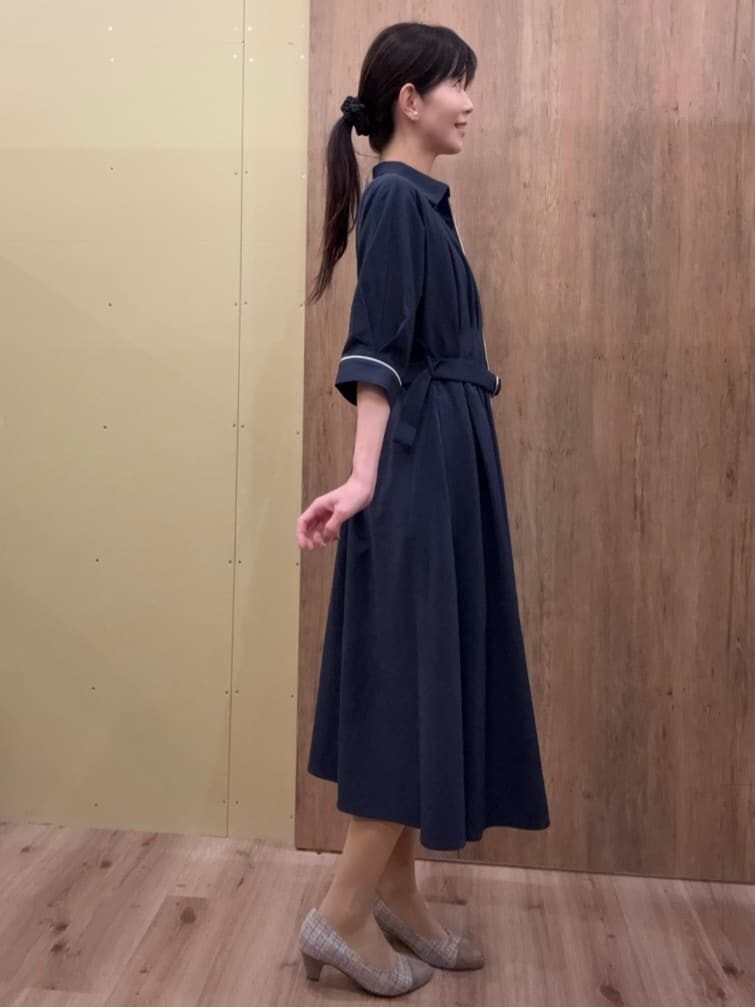 ブラウン系のパンプス、ブルー系のワンピース、ゴールド系のイヤリングを着用したレディースの春コーディネートの2枚目の写真