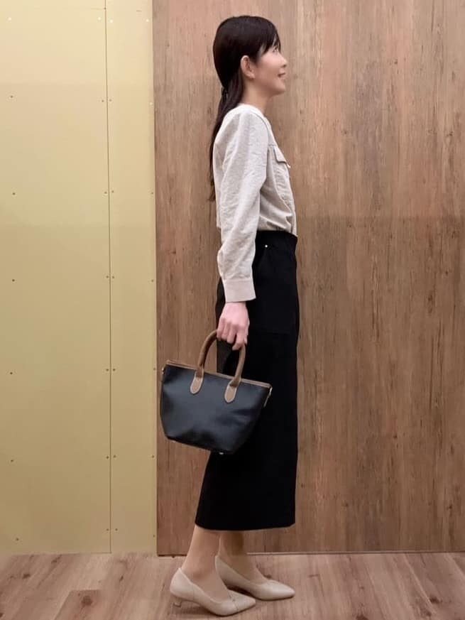 ブラック系のトートバッグ、ベージュ系のパンプス、ベージュ系のシャツ/ブラウスを着用したレディースの春コーディネートの2枚目の写真