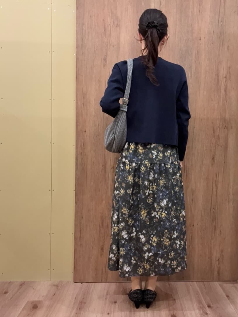 ブラック系のパンプス、シルバー系のショルダーバッグ、グリーン系のワンピースを着用したレディースの冬コーディネートの3枚目の写真