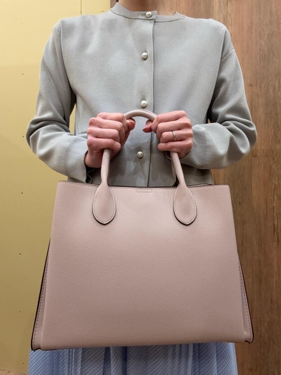 ブラウン系のパンプス、ピンク系のトートバッグ、グレー系のカーディガン/ボレロを着用したレディースの冬コーディネートの5枚目の写真