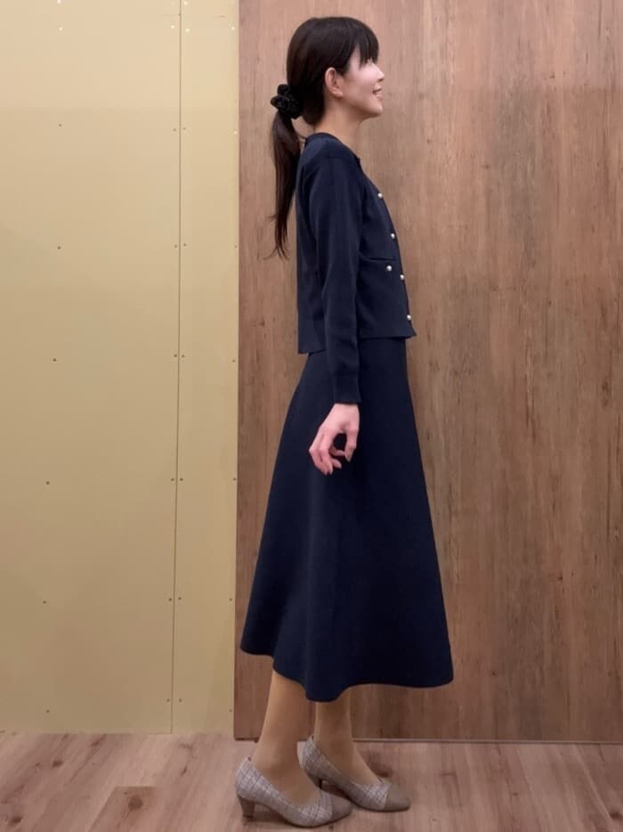 ブラウン系のパンプス、ブルー系のスカート、ブルー系のカーディガン/ボレロを着用したレディースの春コーディネートの2枚目の写真