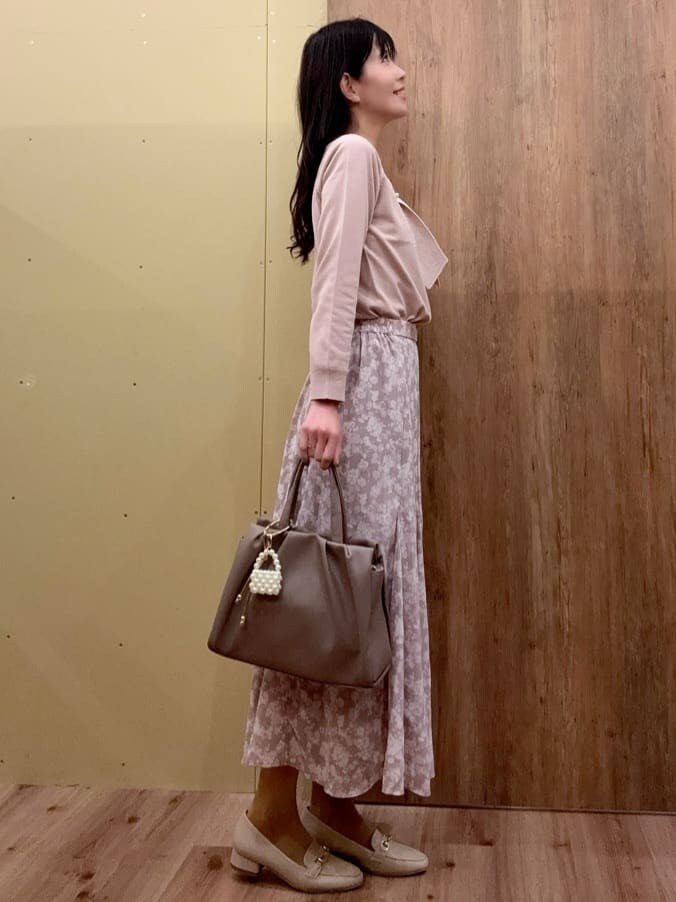 ベージュ系のパンプス、ブラウン系のトートバッグ、ピンク系のスカートを着用したレディースの春コーディネートの2枚目の写真
