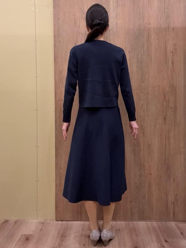 ブラウン系のパンプス、ブルー系のスカート、ブルー系のカーディガン/ボレロを着用したレディースの春コーディネートの3枚目の写真