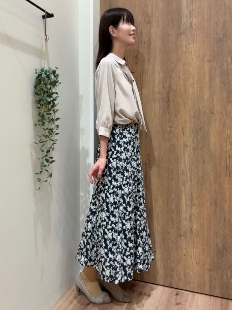 ブラウン系のパンプス、ブルー系のスカート、ベージュ系のシャツ/ブラウスを着用したレディースの春コーディネートの2枚目の写真