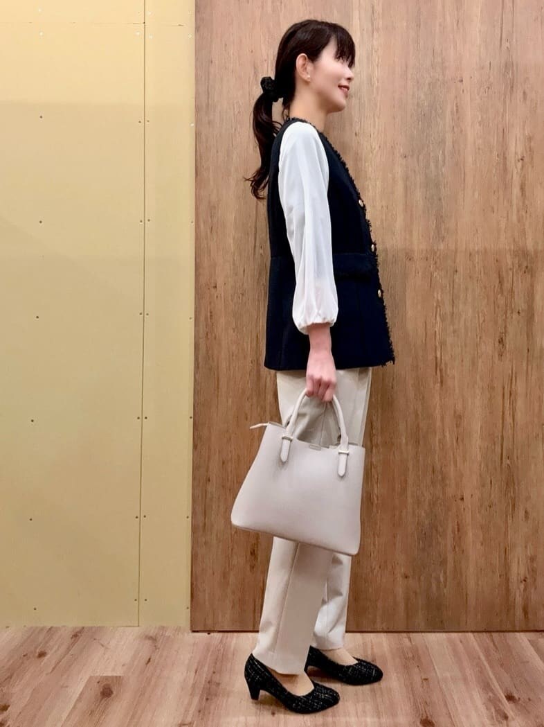 ブラック系のパンプス、ベージュ系のその他パンツ、ブルー系のベストを着用したレディースの冬コーディネートの3枚目の写真