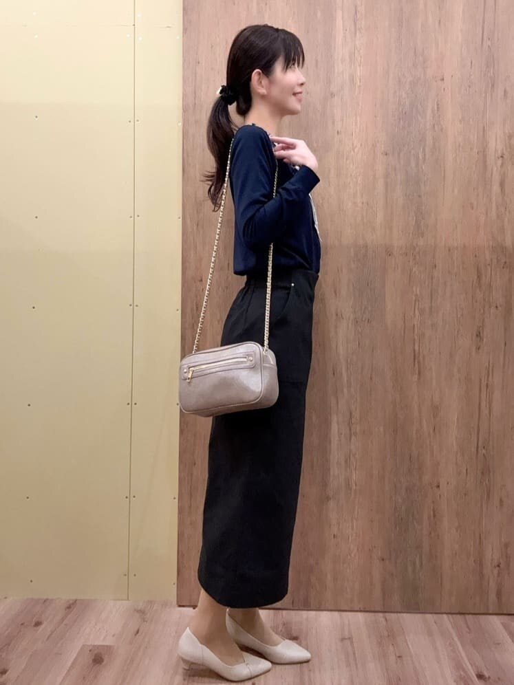 グレー系のショルダーバッグ、ベージュ系のパンプス、ブルー系のニット/セーターを着用したレディースの春コーディネートの2枚目の写真