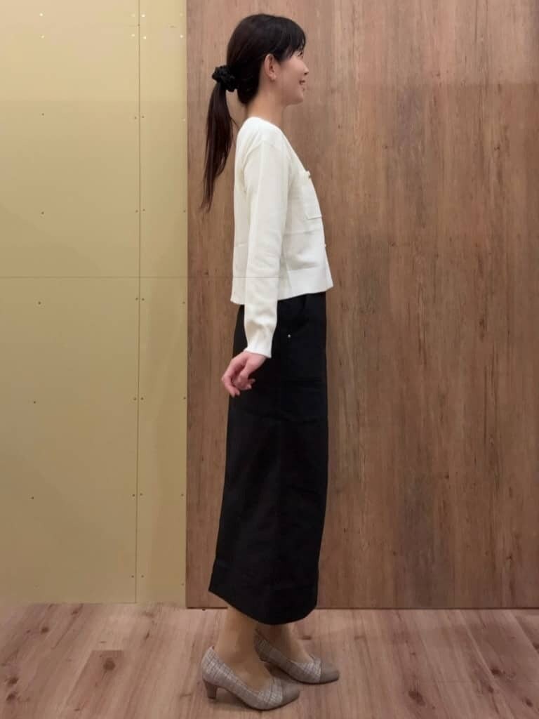 ブラウン系のパンプス、ブラック系のスカート、ホワイト系のカーディガン/ボレロを着用したレディースの春コーディネートの2枚目の写真