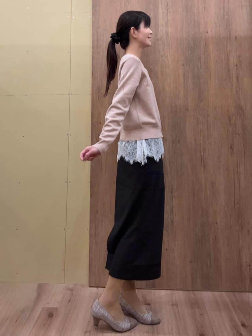 ブラウン系のパンプス、ピンク系のカーディガン/ボレロ、ブラック系のスカートを着用したレディースの春コーディネートの2枚目の写真