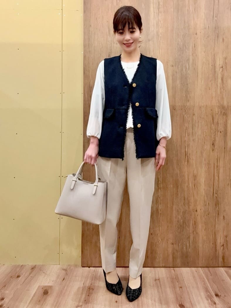ブラック系のパンプス、ベージュ系のその他パンツ、ブルー系のベストを着用したレディースの冬コーディネートの2枚目の写真