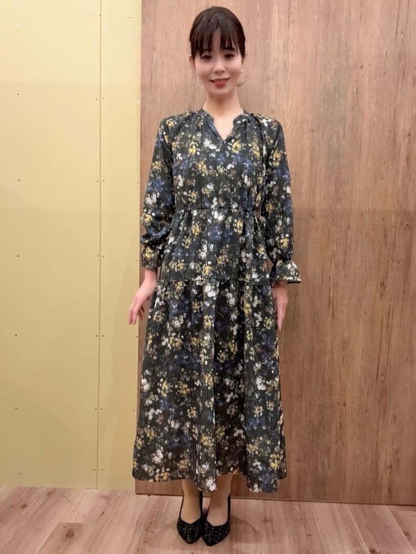 ブラック系のパンプス、シルバー系のショルダーバッグ、グリーン系のワンピースを着用したレディースの冬コーディネートの6枚目の写真
