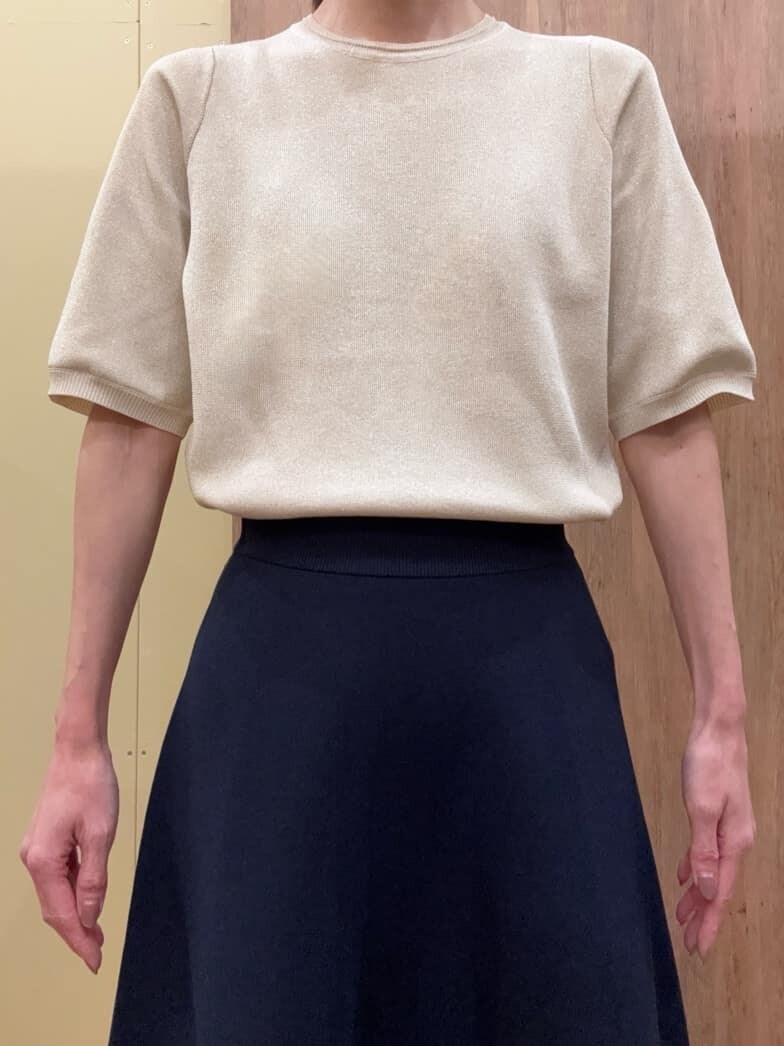 ブラウン系のパンプス、ブルー系のスカート、ゴールド系のニット/セーターを着用したレディースの春コーディネートの4枚目の写真