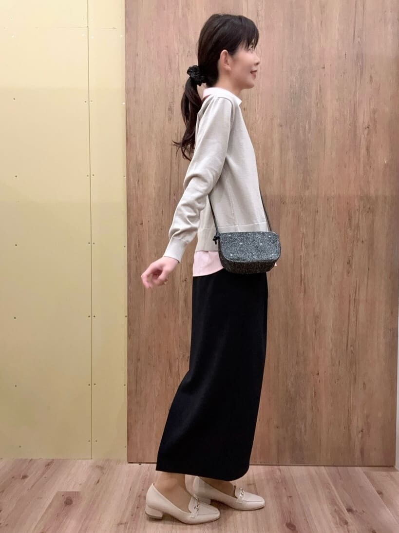 ベージュ系のパンプス、ブラック系のスカート、グレー系のその他パンツを着用したレディースの冬コーディネートの2枚目の写真