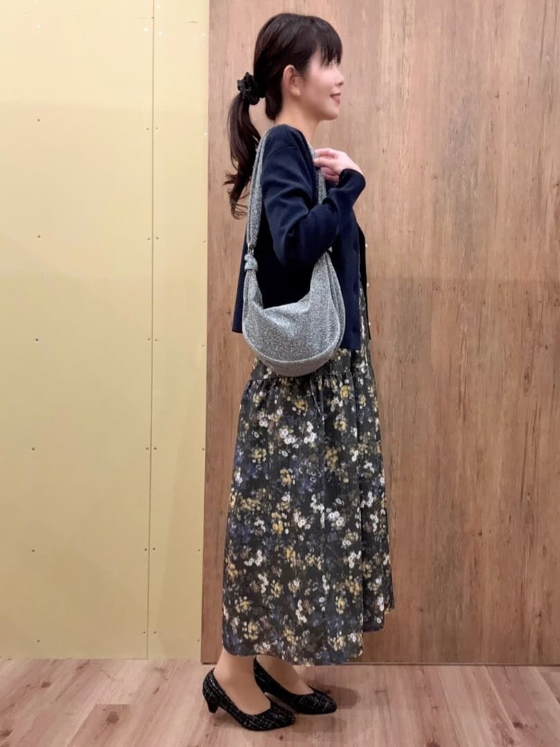 ブラック系のパンプス、シルバー系のショルダーバッグ、グリーン系のワンピースを着用したレディースの冬コーディネートの2枚目の写真