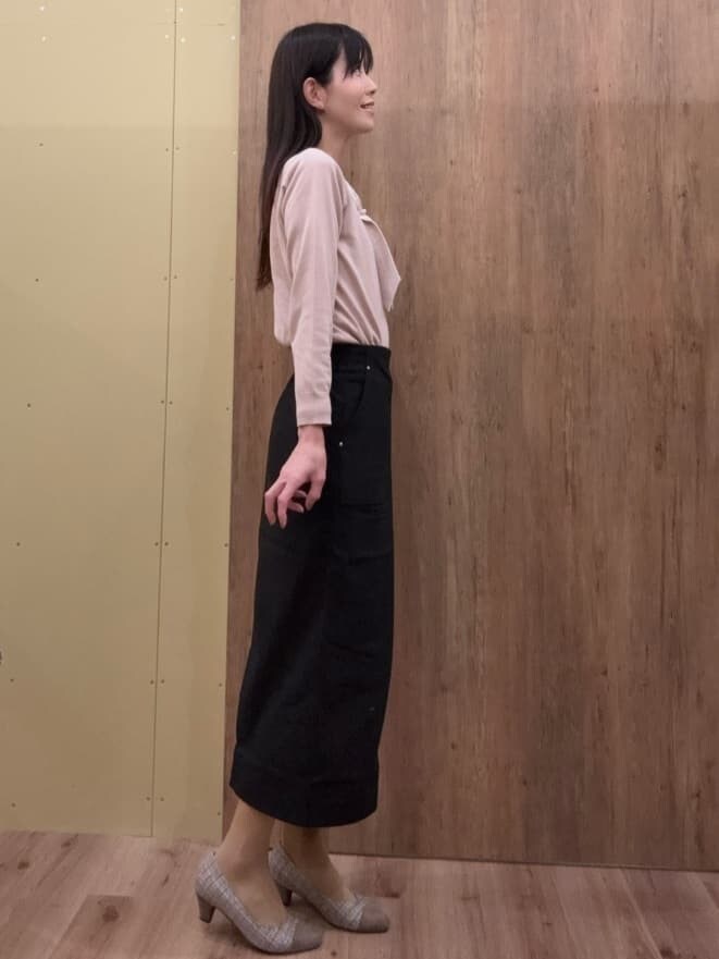 ブラウン系のパンプス、ピンク系のニット/セーター、ブラック系のスカートを着用したレディースの春コーディネートの2枚目の写真