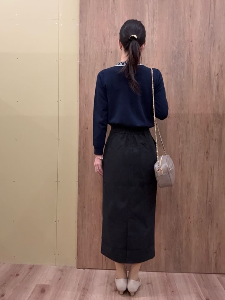 グレー系のショルダーバッグ、ベージュ系のパンプス、ブルー系のニット/セーターを着用したレディースの春コーディネートの4枚目の写真