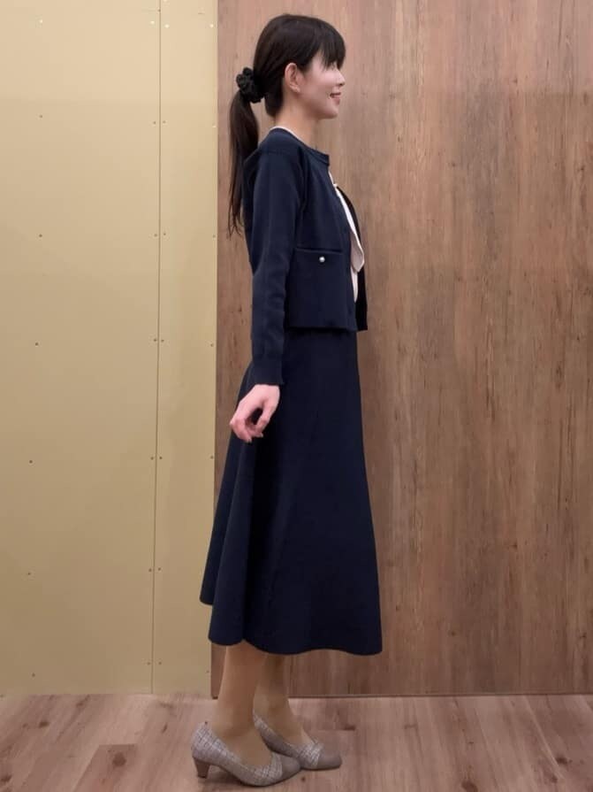 ブラウン系のパンプス、ブルー系のスカート、ブルー系のカーディガン/ボレロを着用したレディースの春コーディネートの2枚目の写真