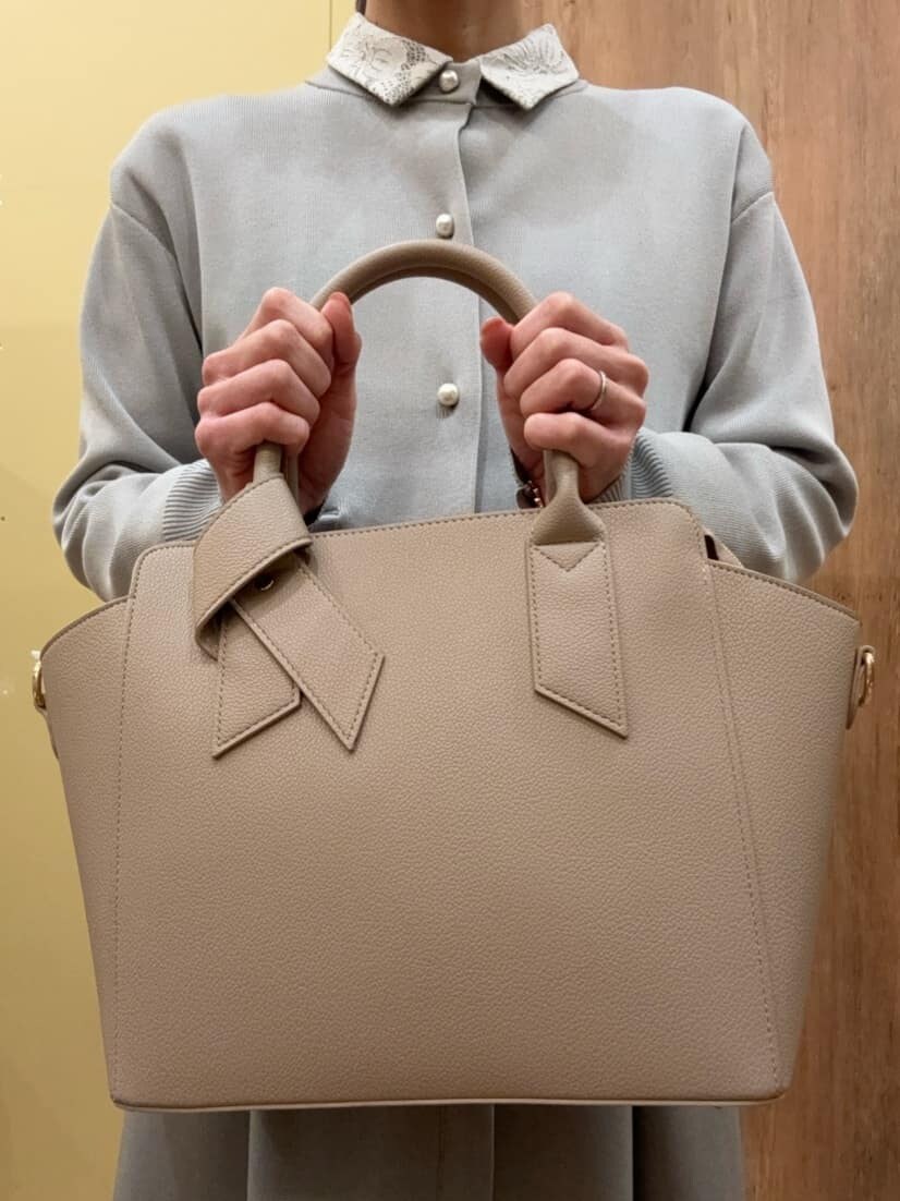ブラウン系のパンプス、グレー系のその他パンツ、ベージュ系のトートバッグを着用したレディースの冬コーディネートの5枚目の写真