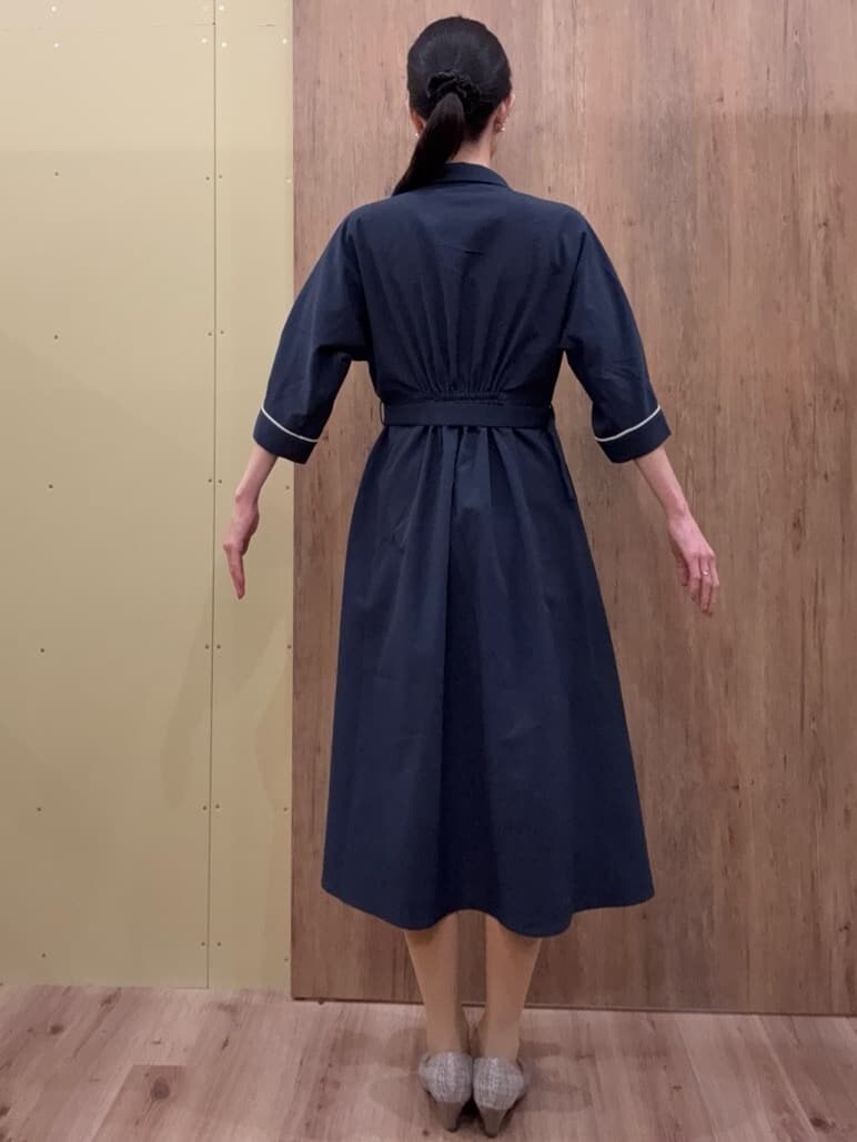 ブラウン系のパンプス、ブルー系のワンピース、ゴールド系のイヤリングを着用したレディースの春コーディネートの3枚目の写真