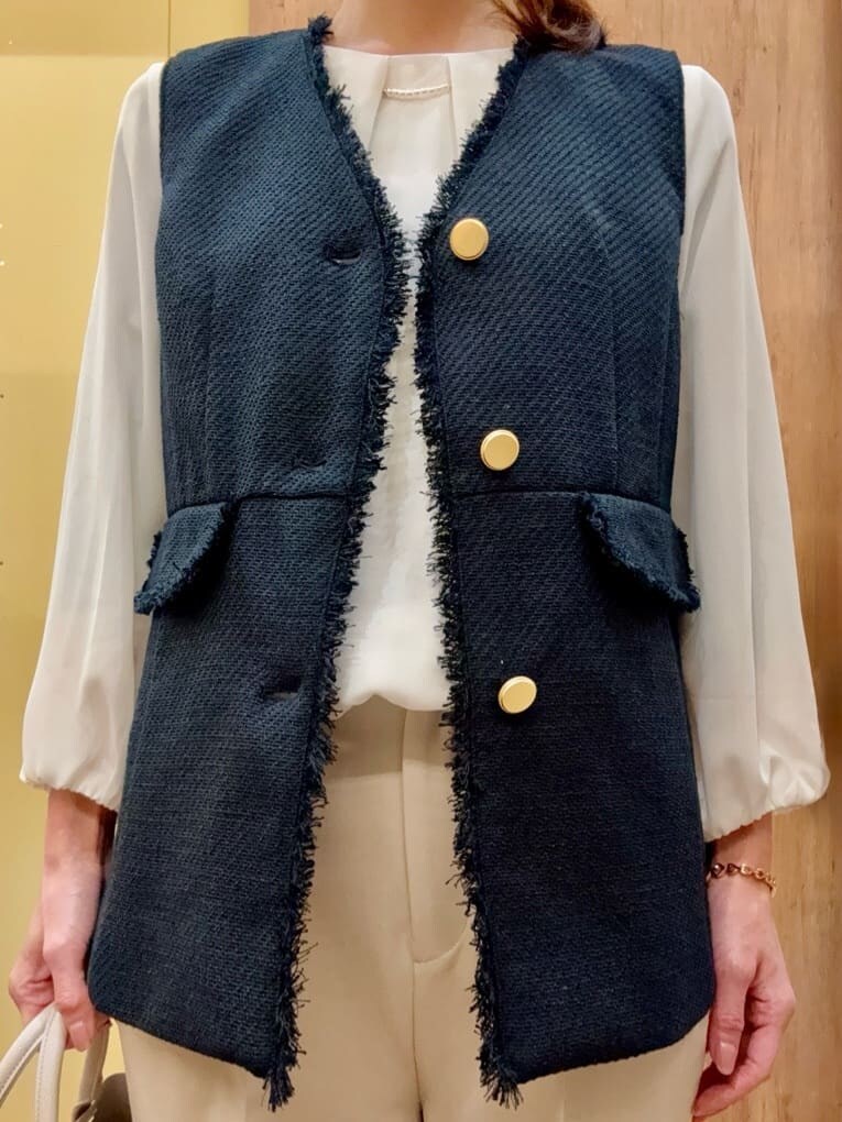 ブラック系のパンプス、ベージュ系のその他パンツ、ブルー系のベストを着用したレディースの冬コーディネートの6枚目の写真