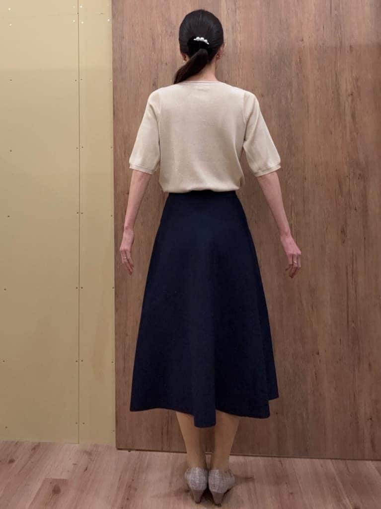 ブラウン系のパンプス、ブルー系のスカート、ゴールド系のニット/セーターを着用したレディースの春コーディネートの3枚目の写真