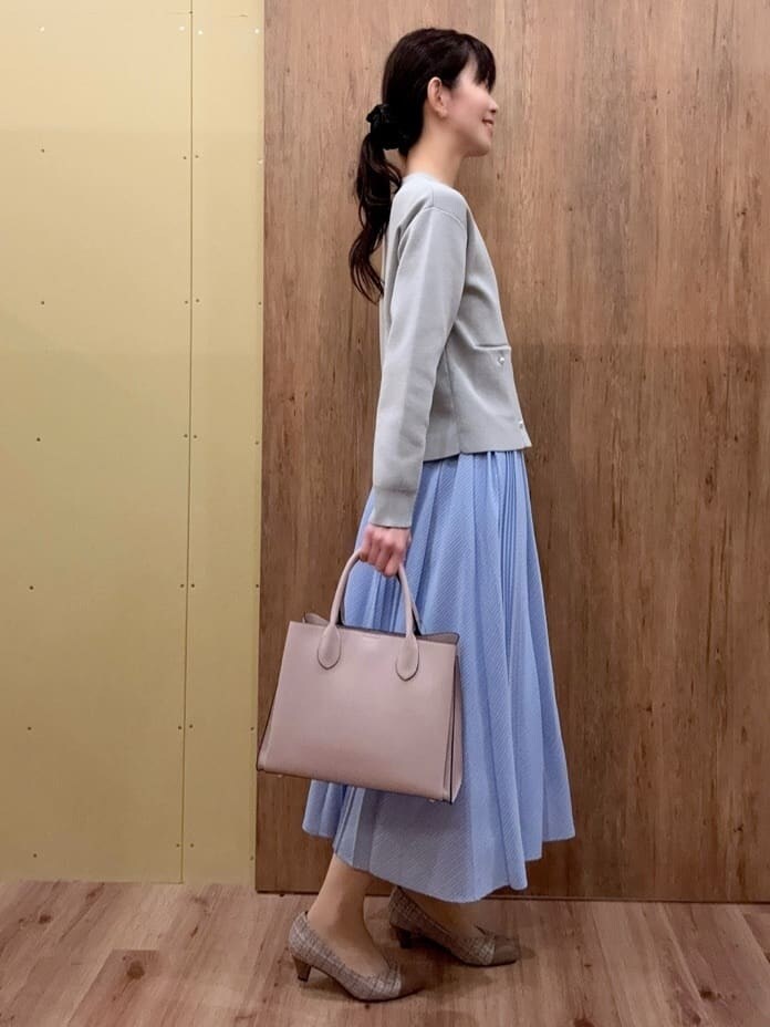 ブラウン系のパンプス、ピンク系のトートバッグ、グレー系のカーディガン/ボレロを着用したレディースの冬コーディネートの2枚目の写真