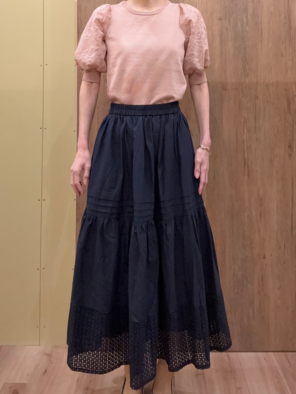 ブラウン系のパンプス、ピンク系のニット/セーター、ブルー系のスカートを着用したレディースの春コーディネートの4枚目の写真