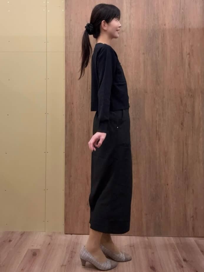 ブラウン系のパンプス、ブラック系のスカート、ブラック系のカーディガン/ボレロを着用したレディースの春コーディネートの2枚目の写真