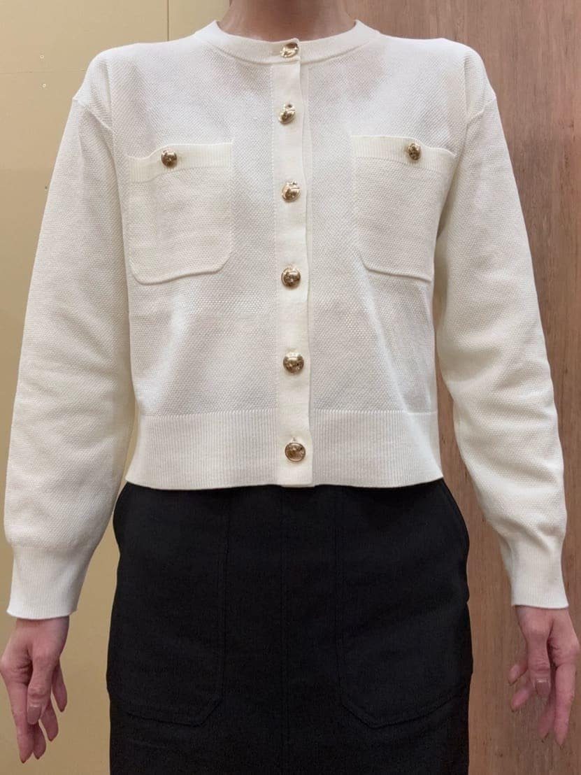 ブラウン系のパンプス、ブラック系のスカート、ホワイト系のカーディガン/ボレロを着用したレディースの春コーディネートの4枚目の写真