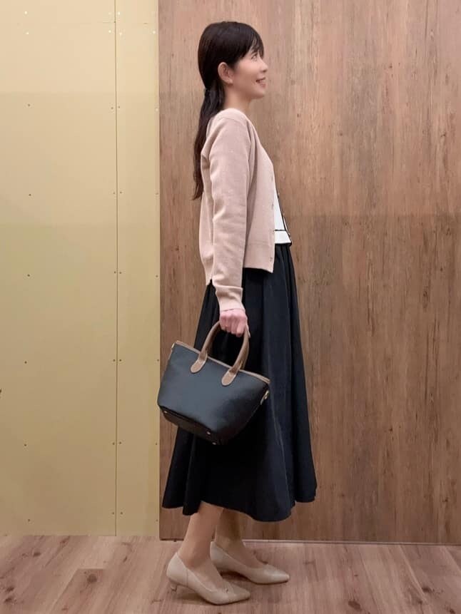 ホワイト系のワンピース、ブラック系のトートバッグ、ベージュ系のパンプスを着用したレディースの春コーディネートの2枚目の写真