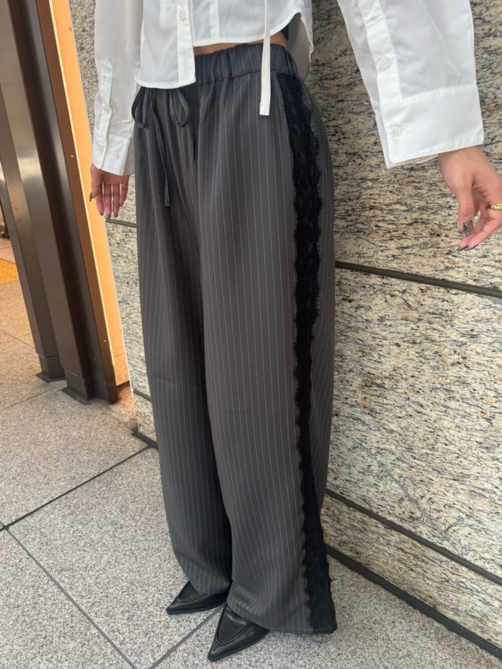 ブラック系のパンプス、グレー系のその他パンツ、ホワイト系のシャツ/ブラウスを着用したレディースの秋コーディネートの5枚目の写真